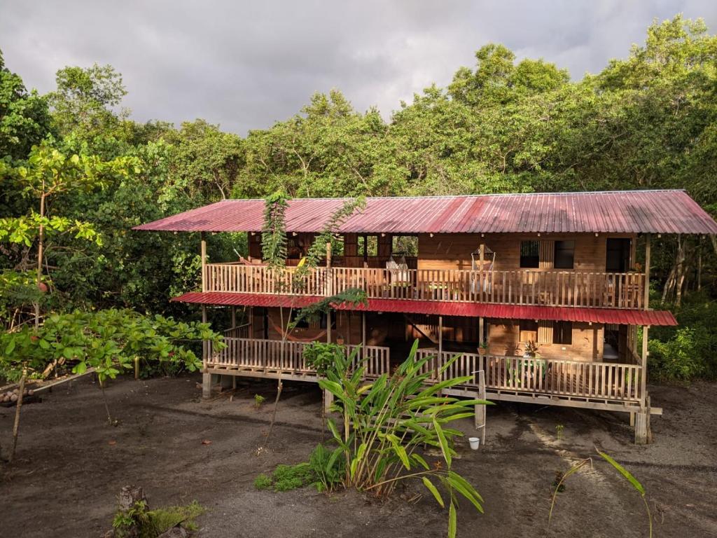 dom z czerwonym dachem w lesie w obiekcie Paraiso Escondido w mieście Bahía Solano