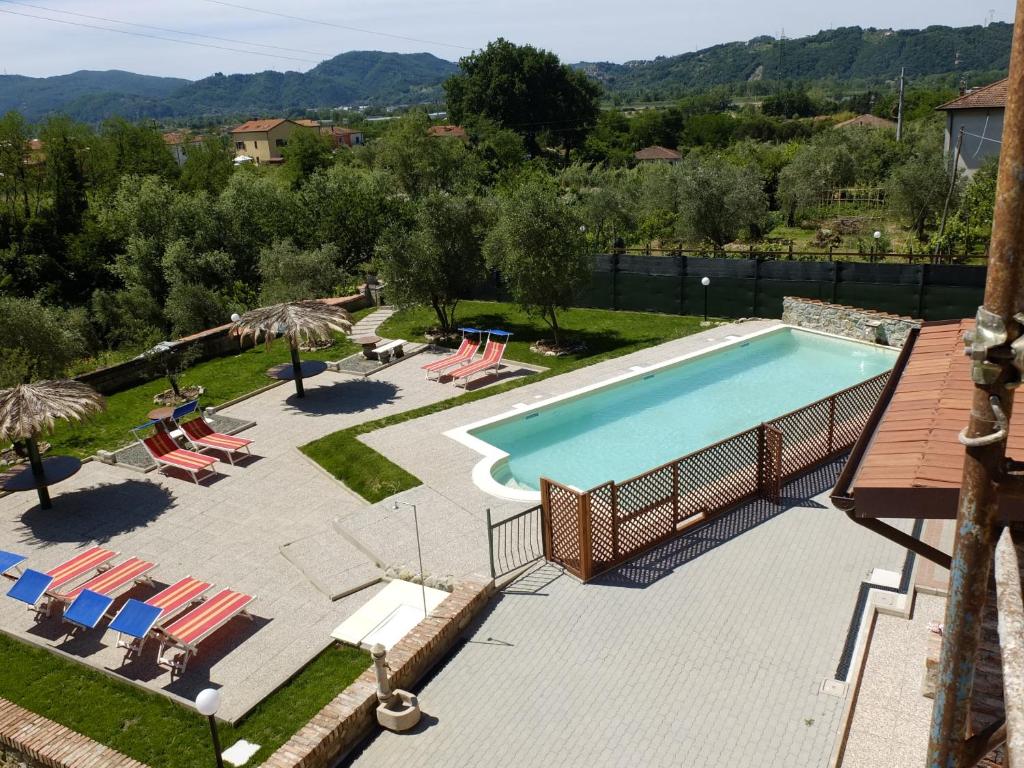 a swimming pool with lounge chairs and a swimming pool at La Fonda Casa Vacanze in Santo Stefano di Magra