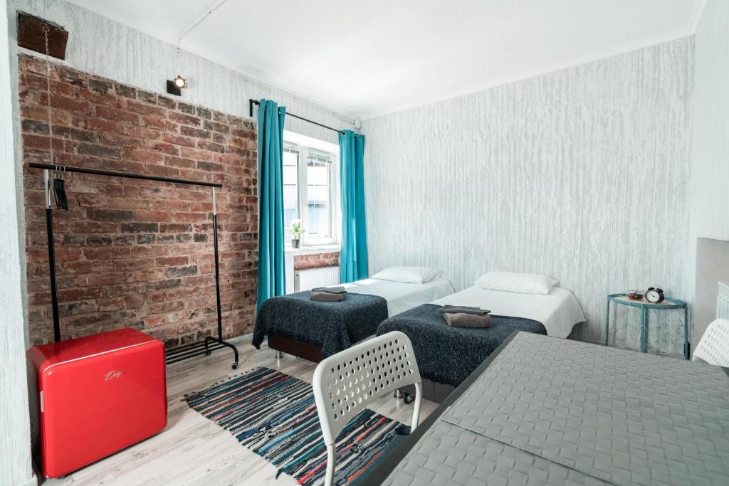 a room with two beds and a brick wall at City Camp in Sortavala