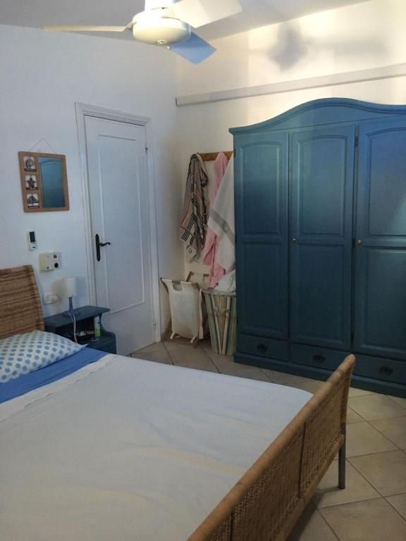a bedroom with a bed and a blue cabinet at Villa Vera trifamigliare con ingresso diretto 20 mt al mare clima wi-fi bbq in Cala Liberotto