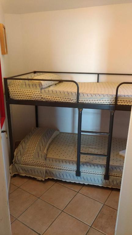 two empty bunk beds in a room at Villa Vera trifamigliare con ingresso diretto 20 mt al mare clima wi-fi bbq in Cala Liberotto