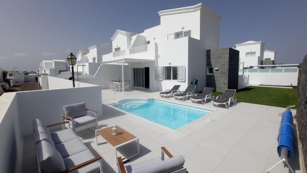 een villa met een zwembad op een dak bij VILLA TRAFALGAR, magnífica casa en la costa ideal para familias que buscan tranquilidad in Playa Blanca