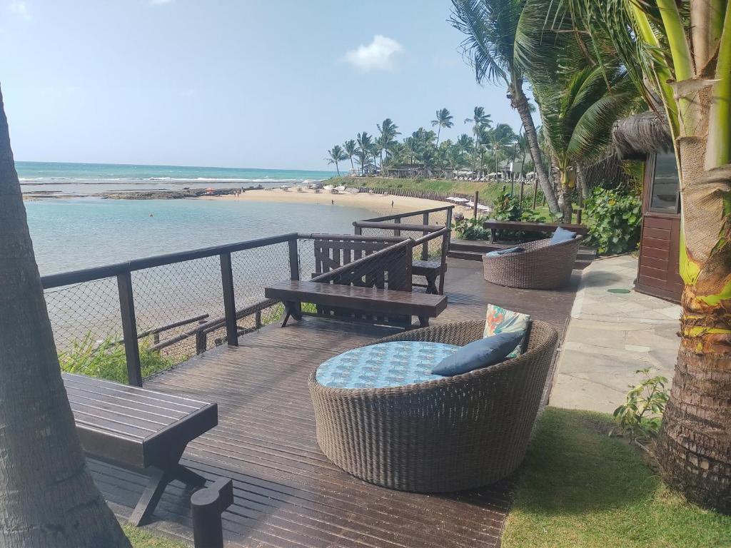 eine Terrasse mit Bänken und Strandblick in der Unterkunft Nannai Residence Porto Galinhas Praia Muro Alto 101 in Porto De Galinhas