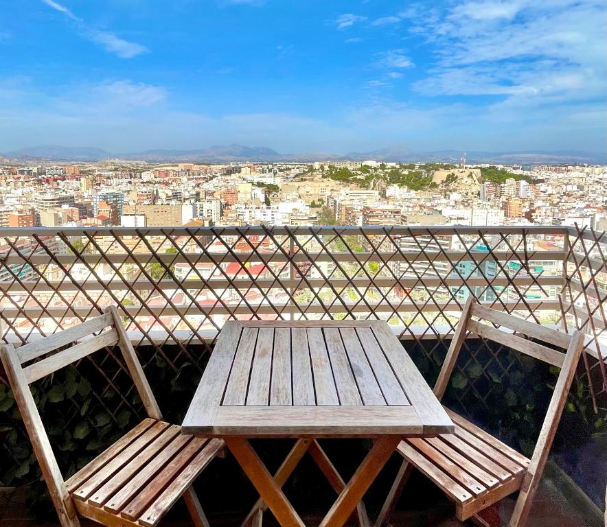 uma mesa de madeira e cadeiras sentadas em cima de uma varanda em VistaBonitaHome em Alicante