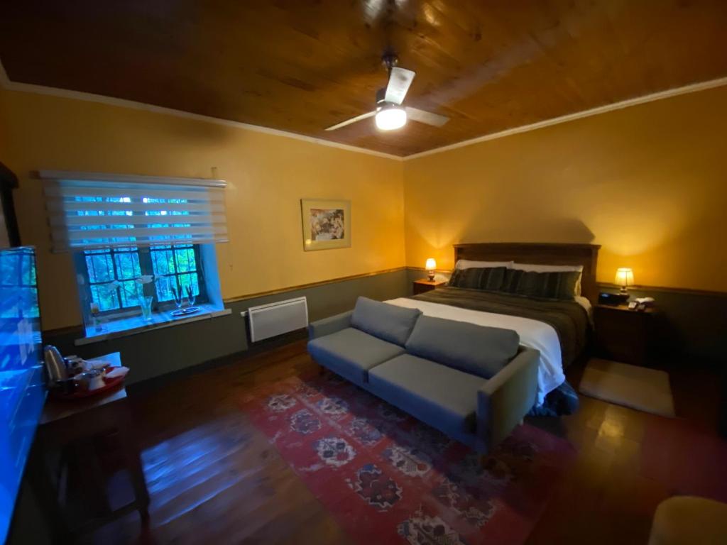 a bedroom with a bed and a couch and a window at The White House by Casona Lo Aguirre - El Monte RM in Talagante