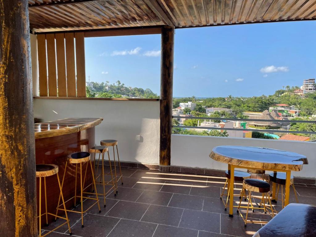 un bar con taburetes y mesas en un balcón en Amanecer en Sayulita