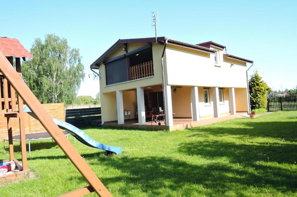 a house with a slide in front of a yard at holiday home, Miedzyzdroje in Międzyzdroje