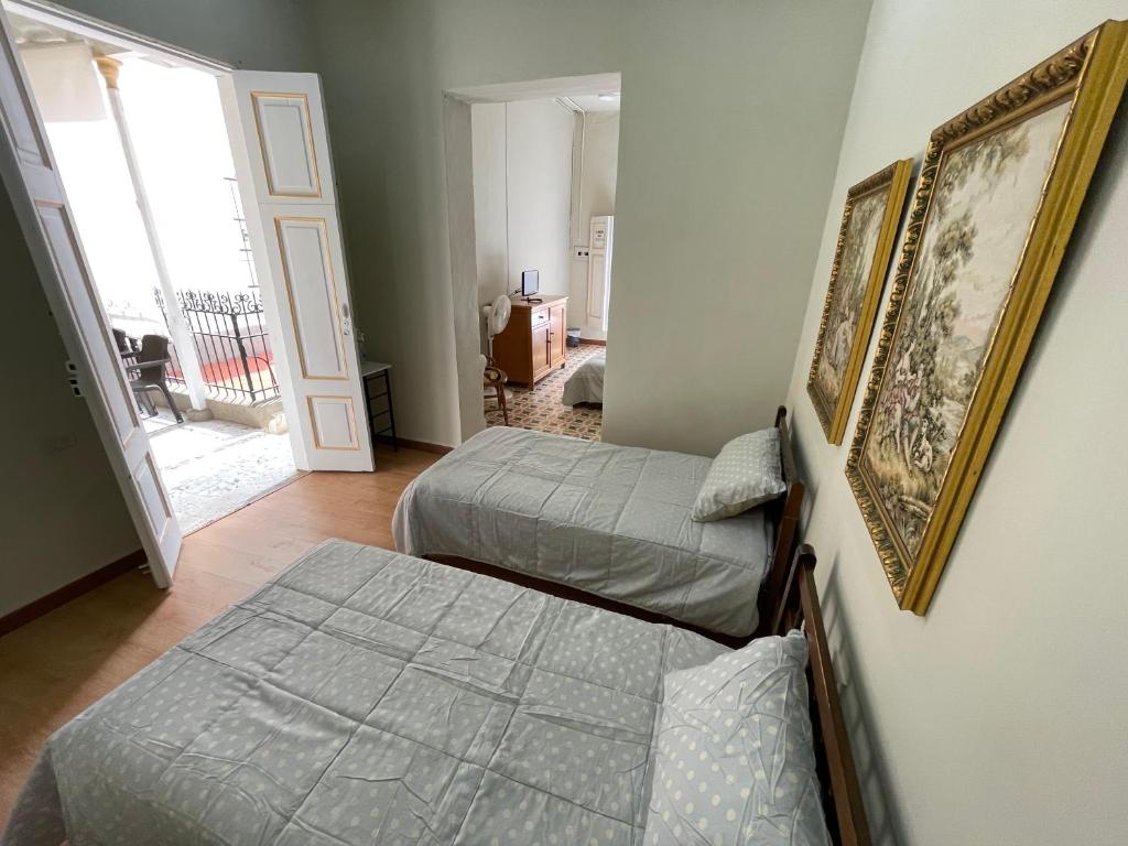 a bedroom with two beds and a hallway with a window at Del Rocío Alojamiento -ANDES in Los Andes