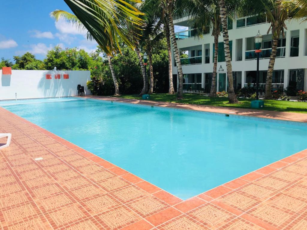 a large blue swimming pool in front of a building at Sunny Confortable Apartment at the Caribe in Punta Cana