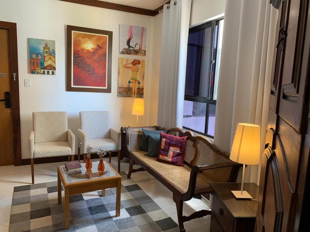 - un salon avec un canapé, des chaises et une table dans l'établissement Apartamento confortável, região do Iguatemi, à Salvador