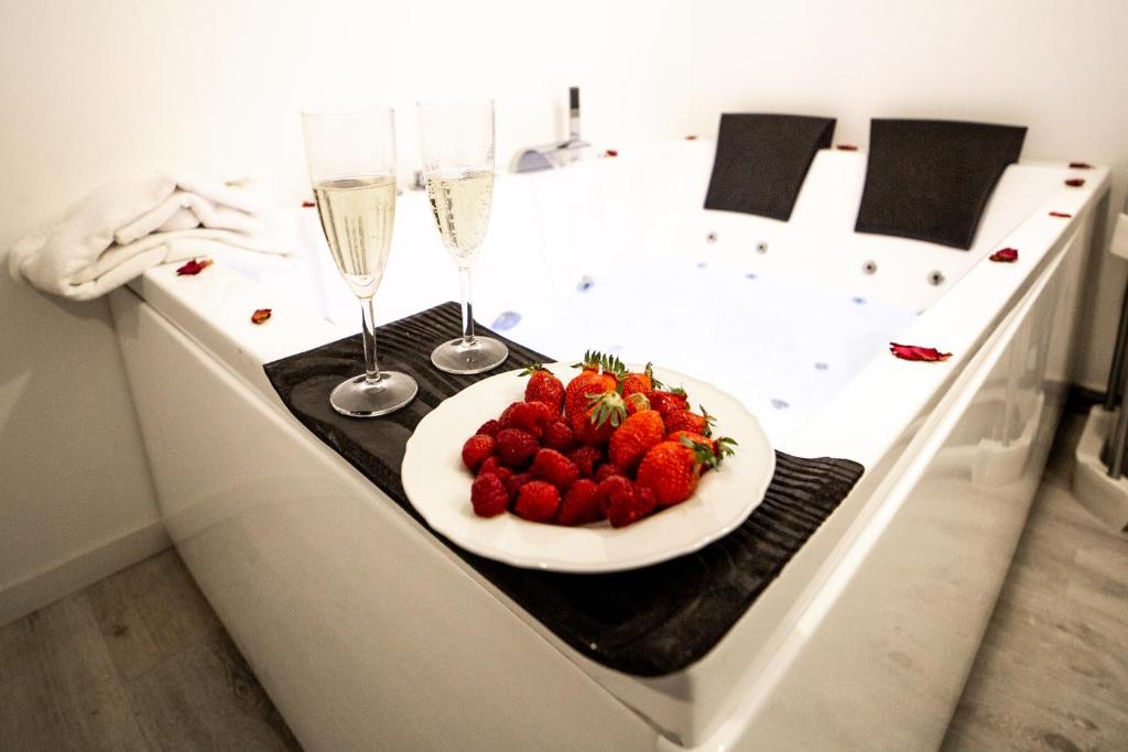 a plate of strawberries on a table with champagne glasses at Odelys Premium in Boulogne-sur-Mer