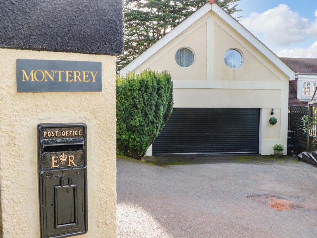 a house with a garage with a sign in front of it at Monterey Mews in Torquay