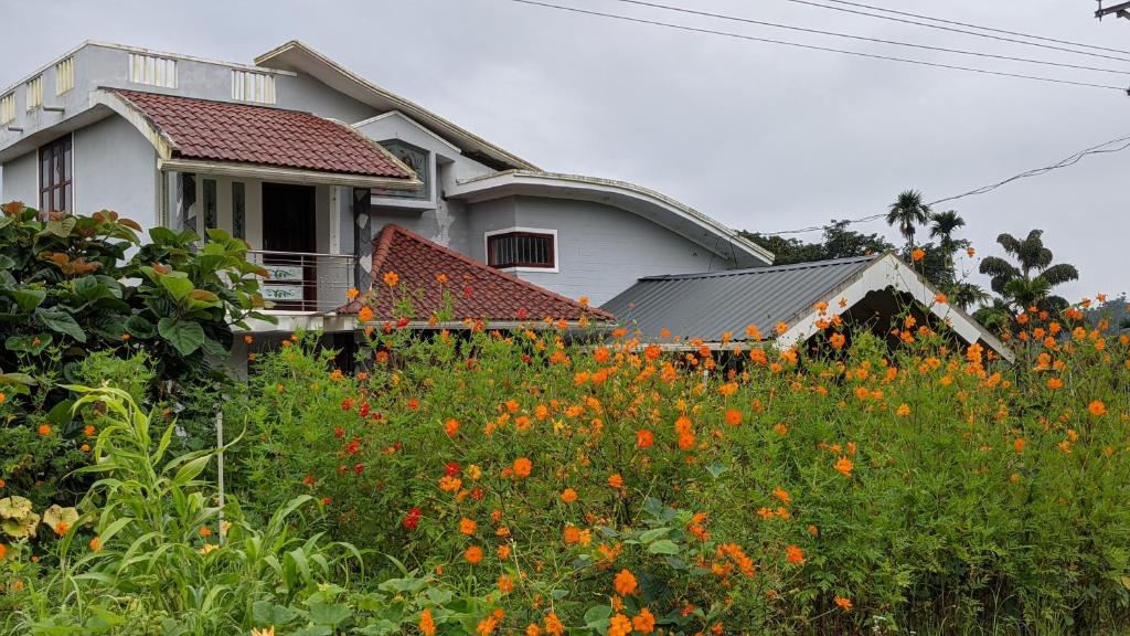 uma casa com um campo de flores em frente em Chamayam Holiday Villa em Meenangadi