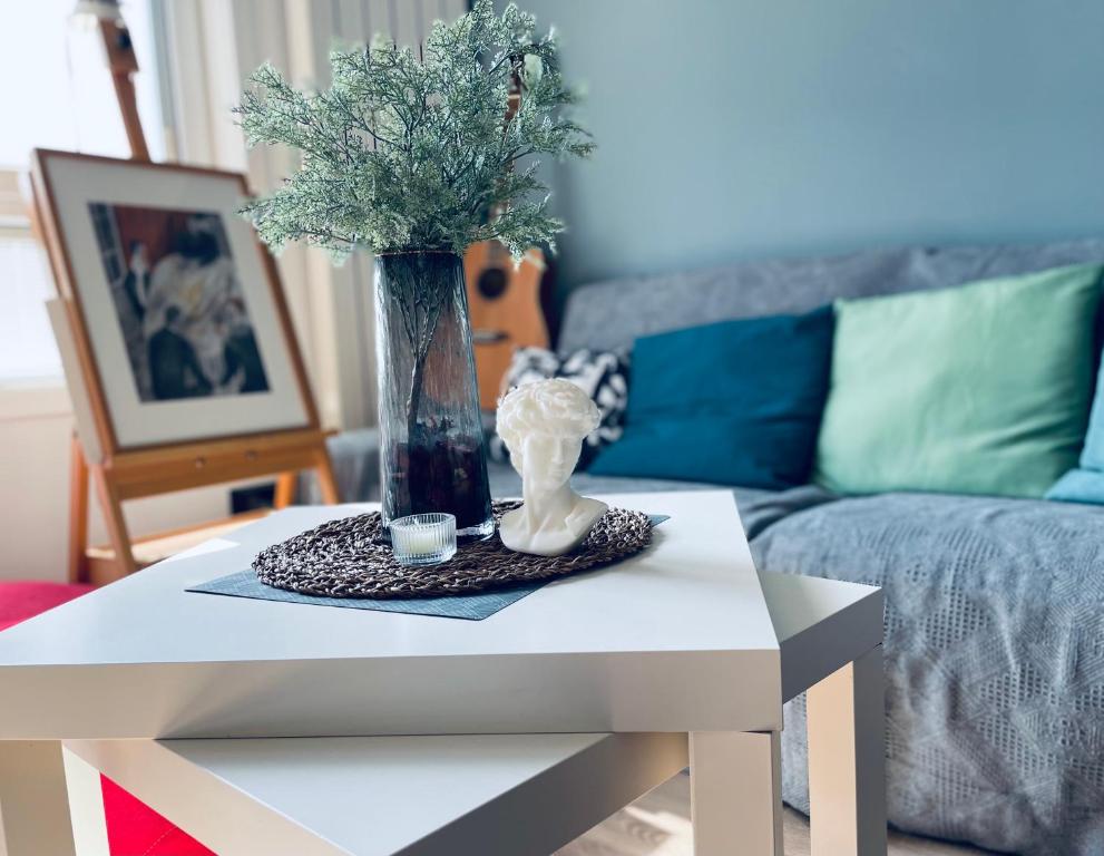 a white coffee table with a vase on top of it at Zhe·Yi Boutique Guesthouse in Beijing