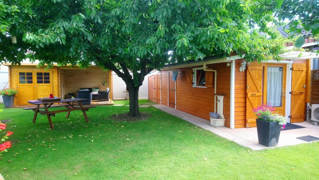 a picnic table under a tree next to a house at Chambre D'hôte "Les Tourtereaux" in Saint-Just-de-Claix