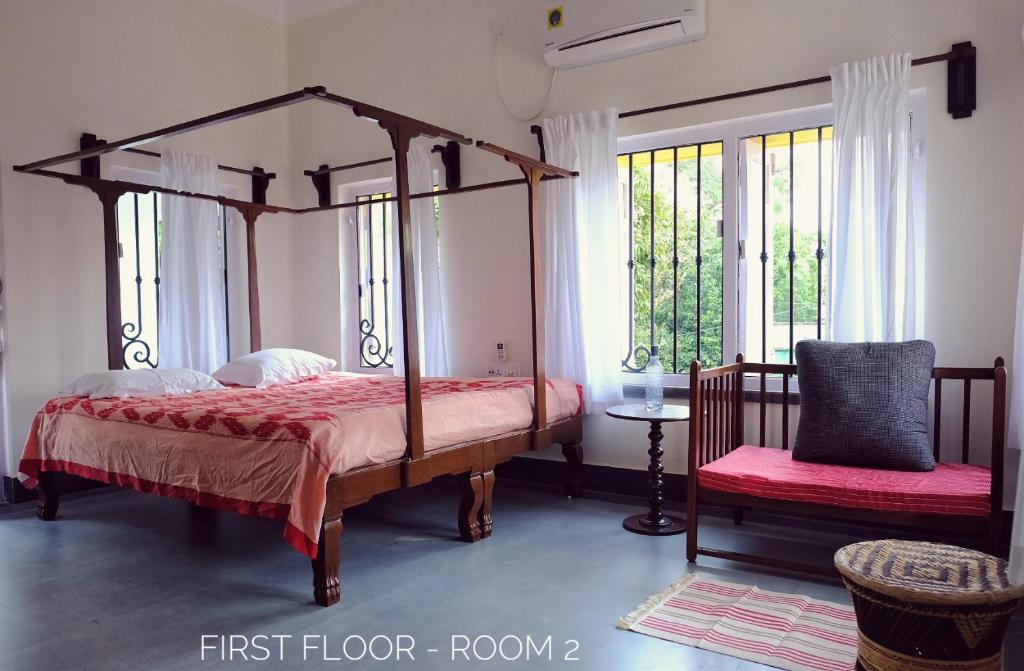 a bedroom with a four poster bed and a window at PARUL - Elegant Heritage Home at the Heart of Shantiniketan in Shānti Niketan