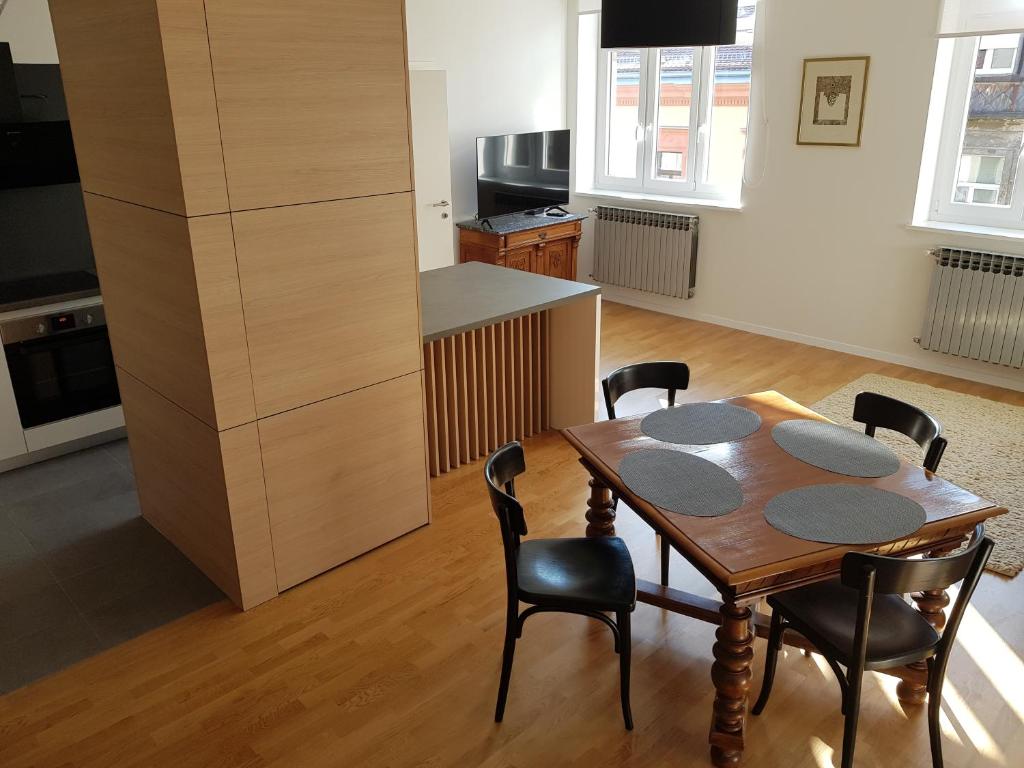 een keuken en eetkamer met een houten tafel en stoelen bij Apartmani Seven App in Zagreb