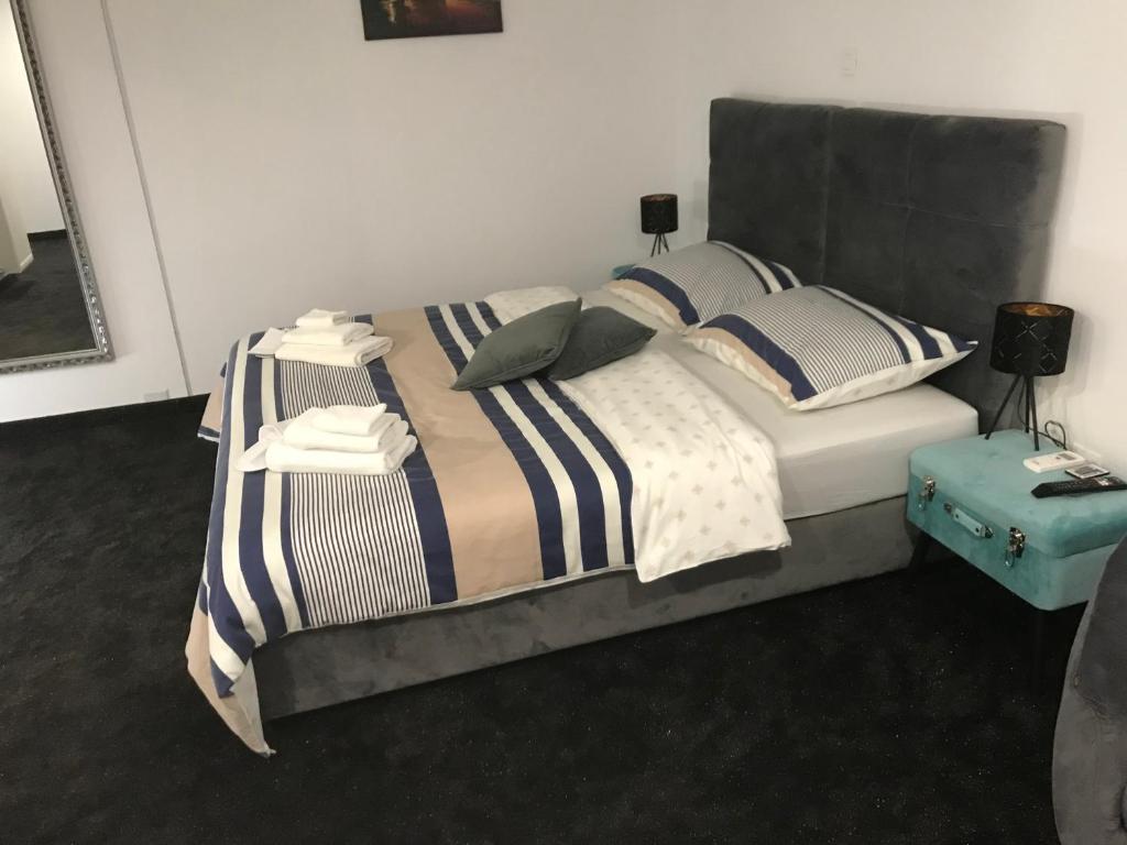 um quarto com uma cama com lençóis e almofadas listradas em WooW Apartments em Velika Gorica