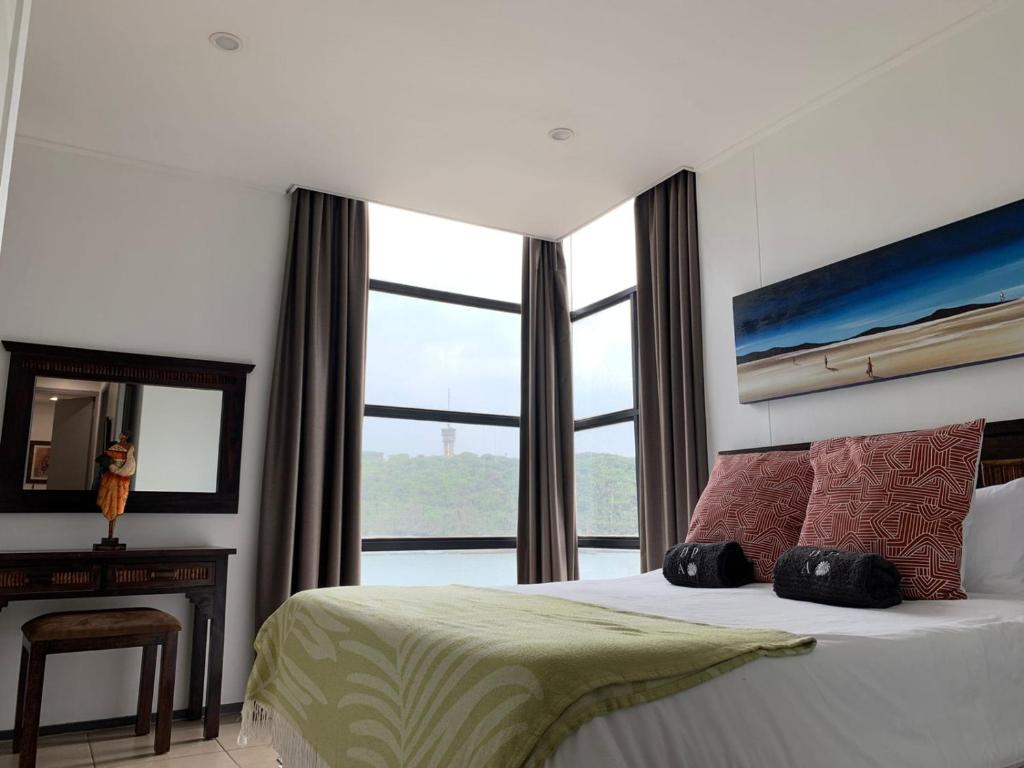 sypialnia z łóżkiem i dużym oknem w obiekcie 307 Point Bay w mieście Durban