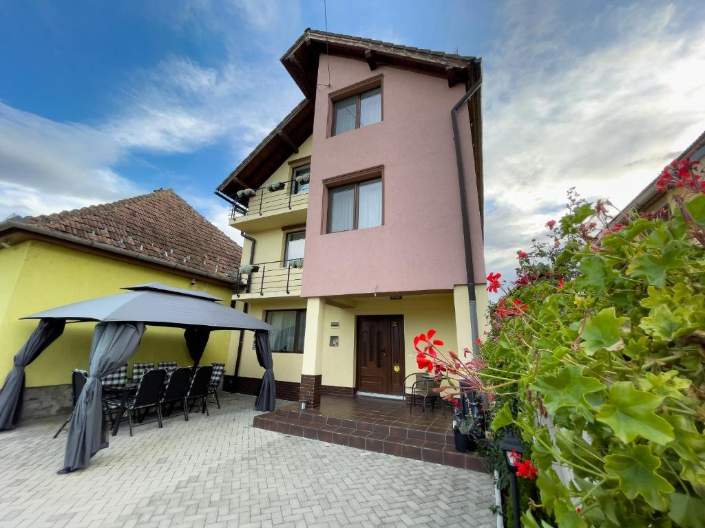 a house with a patio with chairs and an umbrella at Casa Mos in Sibiu