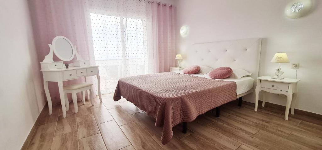 una camera con letto, tavolo da trucco e specchio di Cozy Sea Views Apartment in Costa Adeje ad Adeje