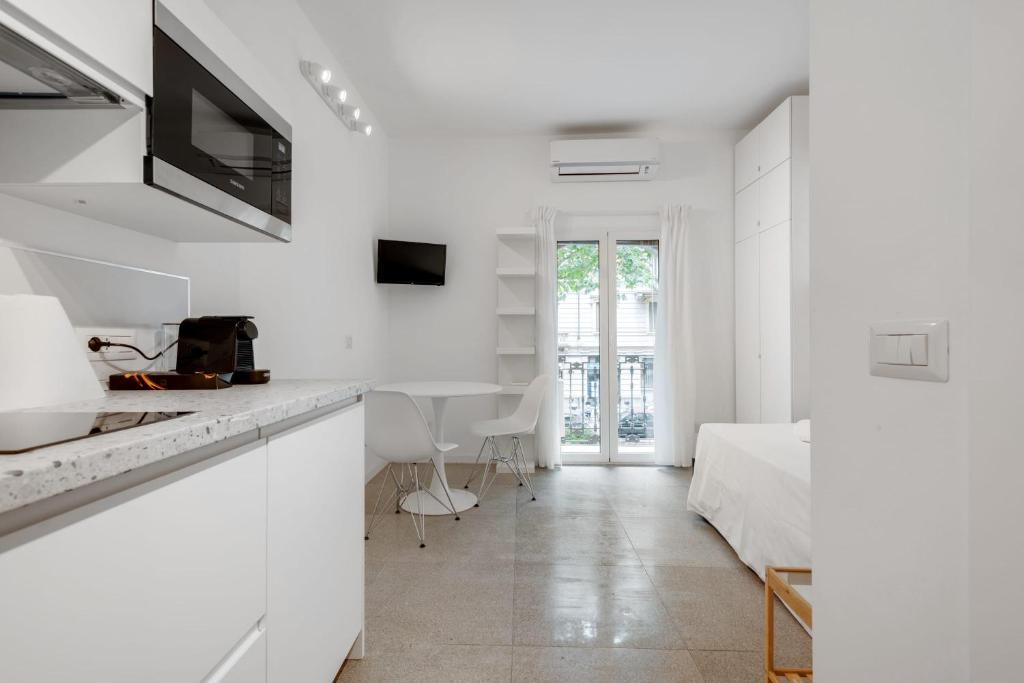 Apartamento blanco con cocina y dormitorio. en Wonderful studio in Pta romana 10 mins from Duomo by Easylife, en Milán