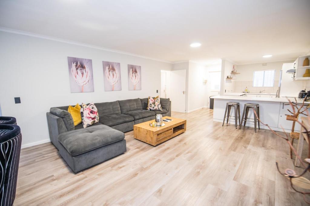 a living room with a couch and a table at Plettenberg Bay Unit 2 Greenpoint Mews Apartment with Backup Power in Plettenberg Bay