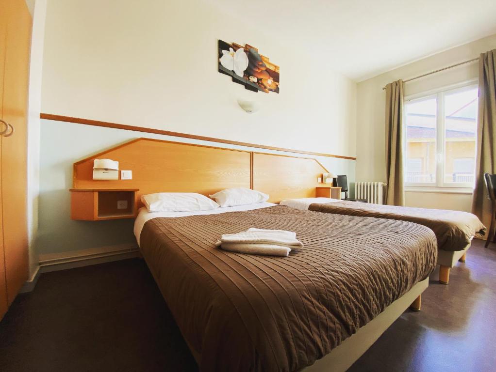 Postel nebo postele na pokoji v ubytování Hotel Le Midi Clermont-Cournon