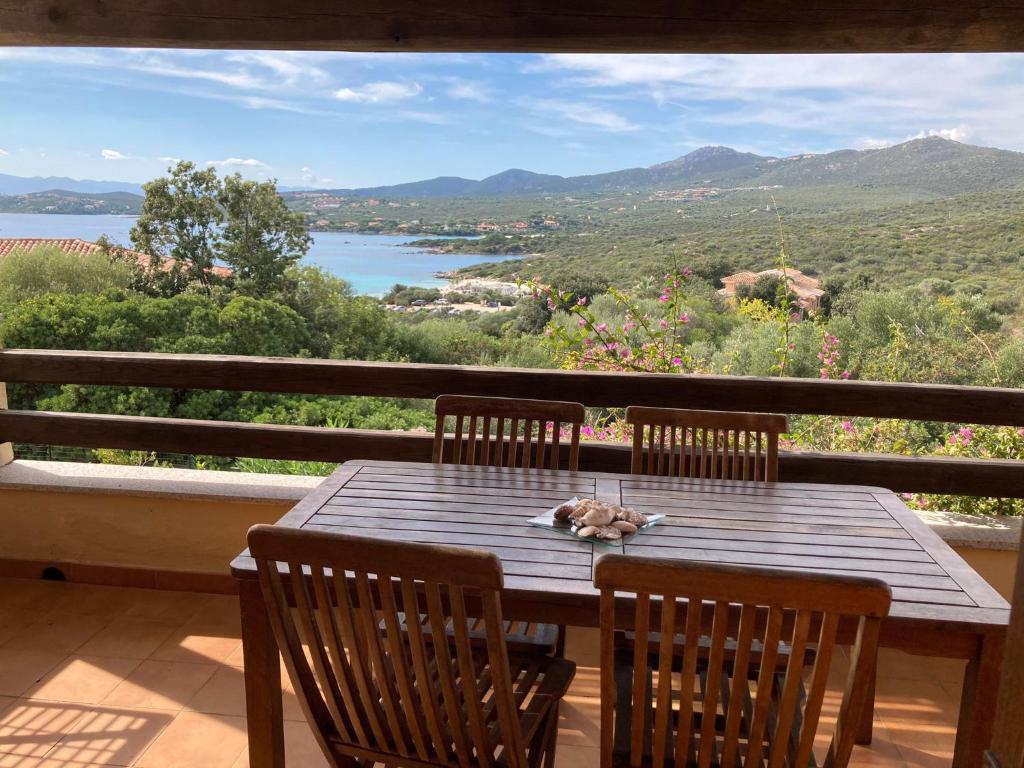 a dog laying on a wooden table on a balcony at Residence Spiaggia Bianca in Golfo Aranci