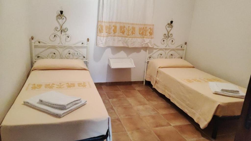 two beds in a small room with towels on them at Residence Spiaggia Bianca in Golfo Aranci