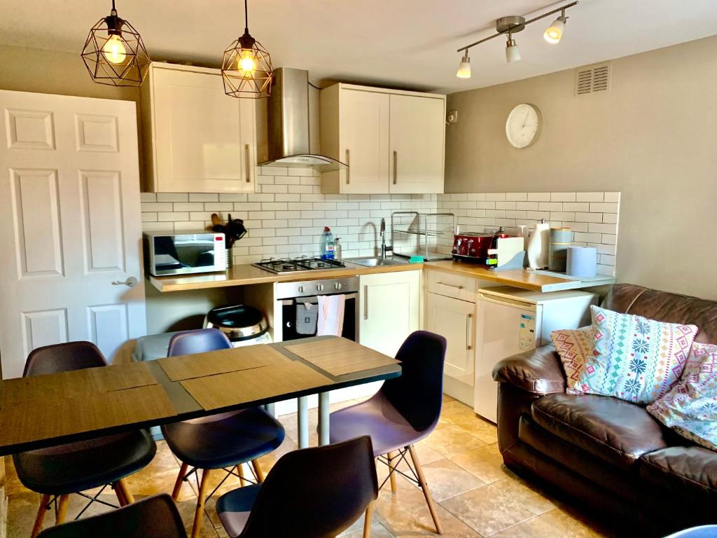 cocina y sala de estar con mesa y sofá en Central City Garden Apartment, en Cardiff