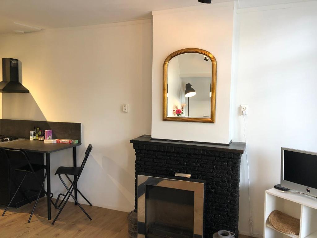un soggiorno con camino e specchio di Thomasloft a Oegstgeest