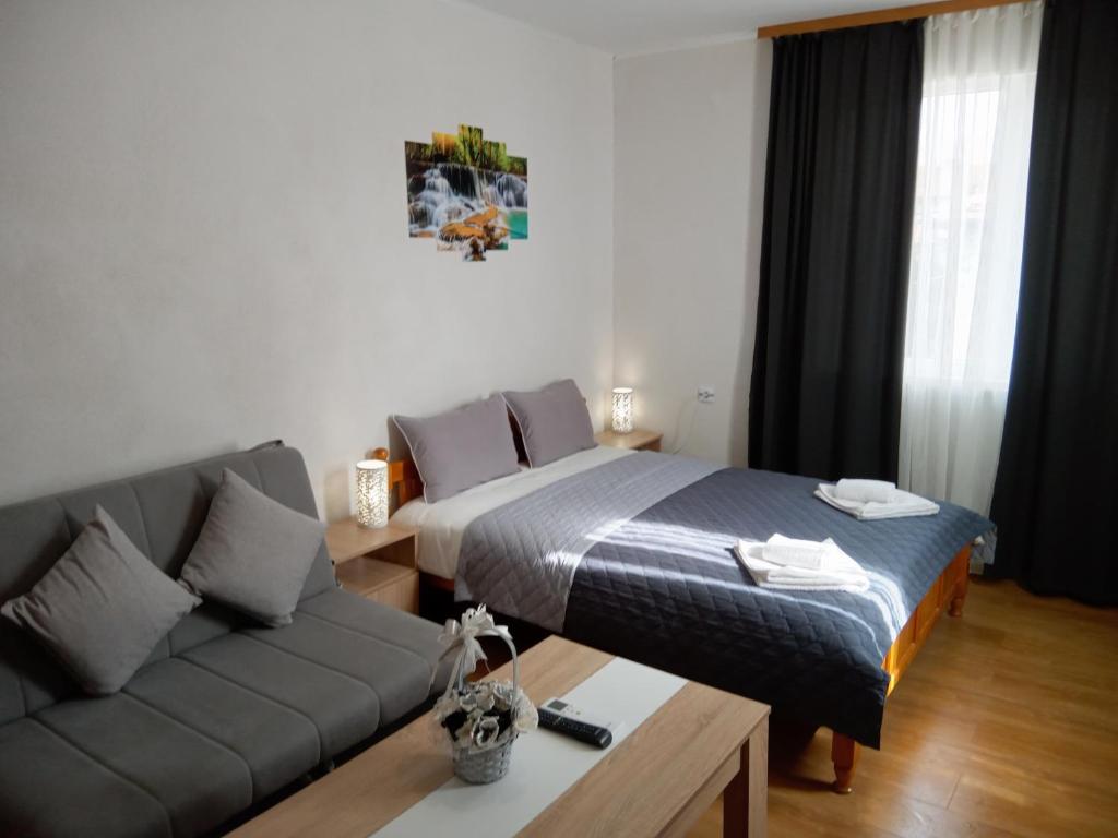 a living room with a bed and a couch at Holiday guest house KEMO in Sapareva Banya