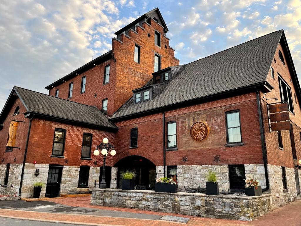 um grande edifício de tijolos vermelhos com um telhado preto em Gamble Mill em Bellefonte