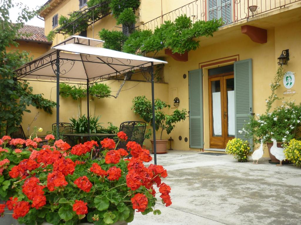 un paraguas y flores frente a un edificio en L'Adele Bed & Breakfast, en Occimiano