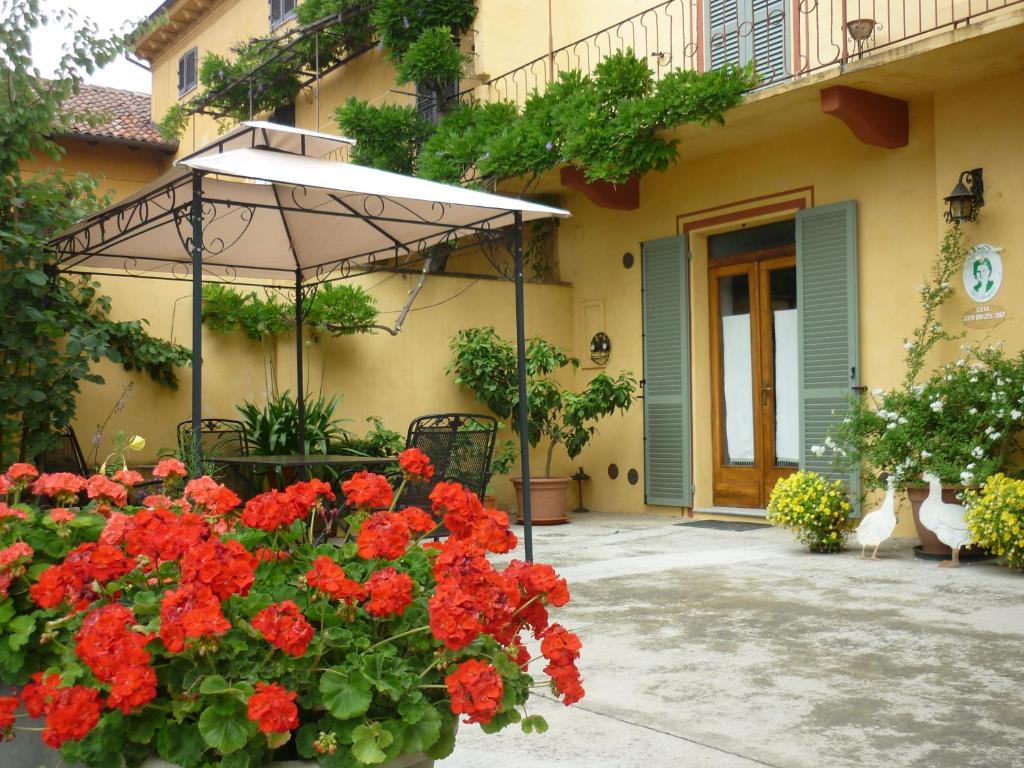 an umbrella and flowers in front of a building at L'Adele Bed & Breakfast in Occimiano