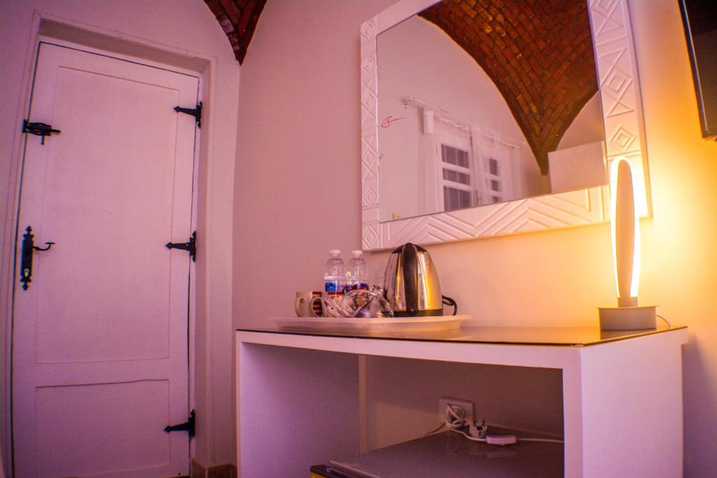 um quarto com uma mesa com um espelho e uma porta em NUB INN em Aswan