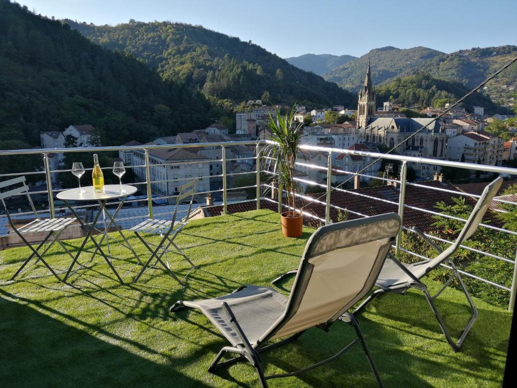 a chair and a table on a balcony with a view at La Dolce Vita Justine in Vals-les-Bains