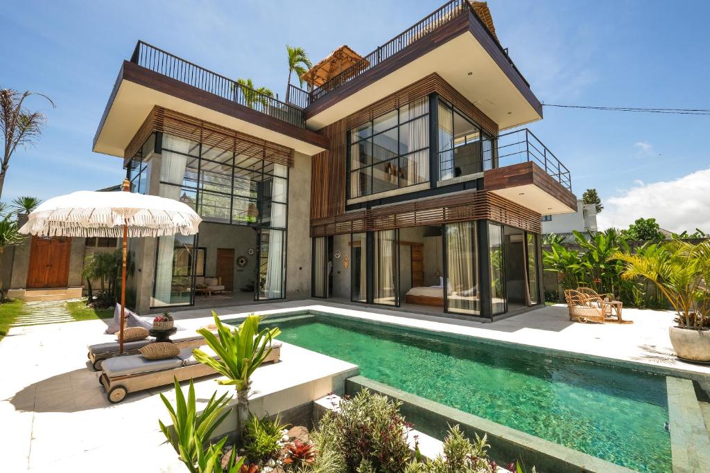 a house with a swimming pool in front of it at Villa Kamal Umalas in Kerobokan