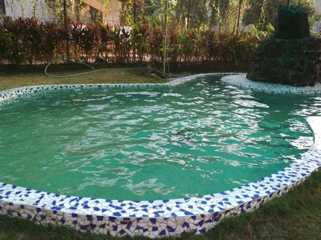 a pool of water in a yard with a fountain at 2Bhk Villa With Private Swimming Pool Alibaug in Alibaug