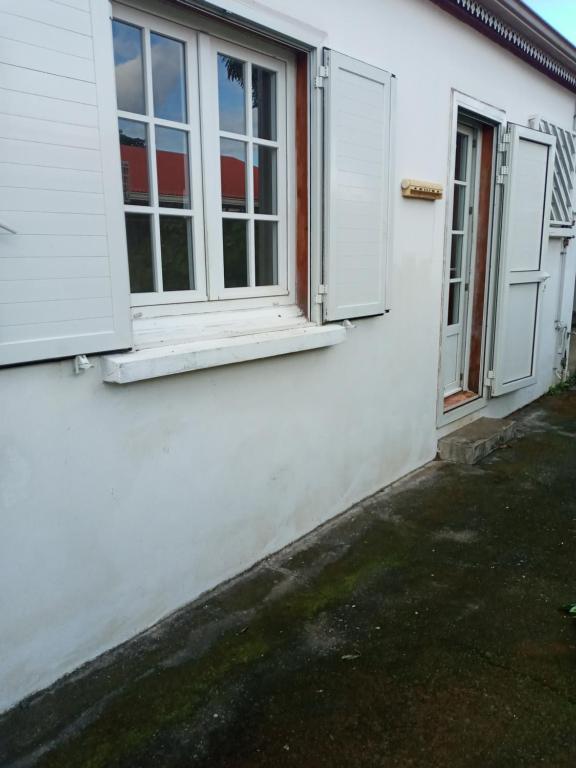 una casa bianca con due finestre e una porta di Chambre privée a Sainte-Suzanne