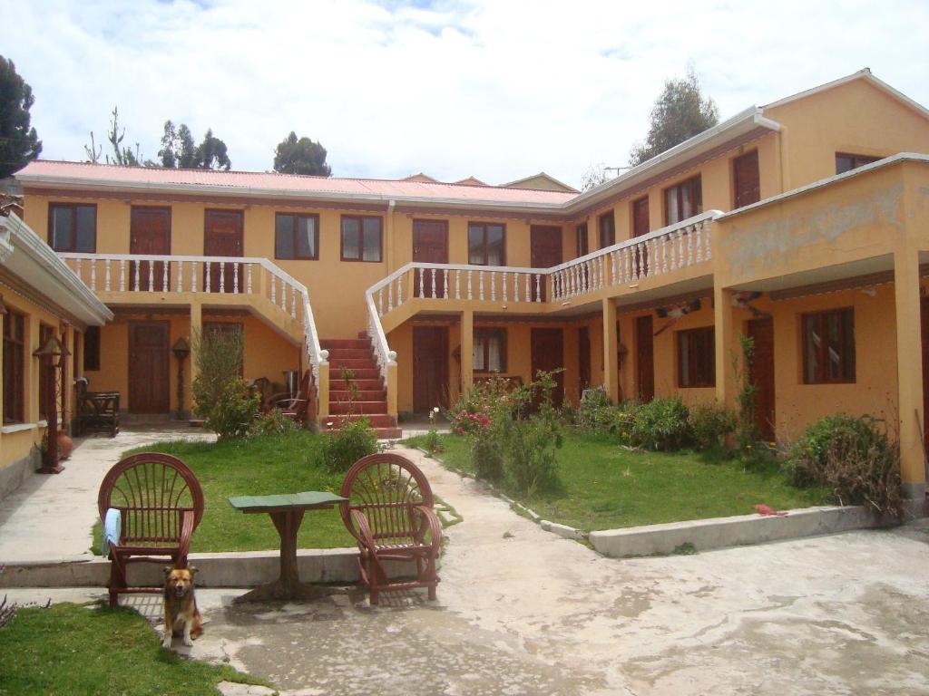 un edificio con 2 sillas y una mesa en el patio en IMPERIO del SOL, en Comunidad Yumani