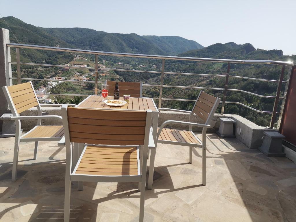 uma mesa e cadeiras numa varanda com vista em Casa Rural Leo: remanso de paz y tranquilidad em Agulo