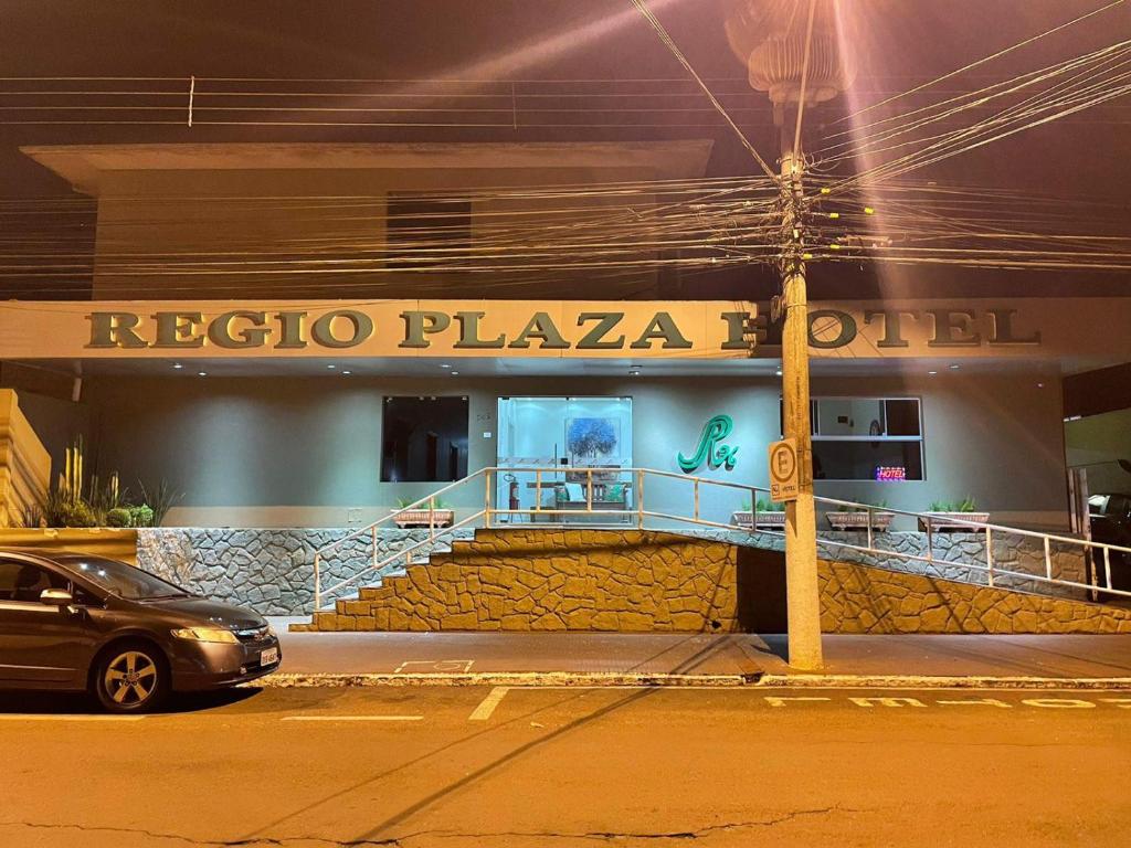 a car parked in front of arizoco plaza hotel at night at Regio Plaza Hotel in Ourinhos