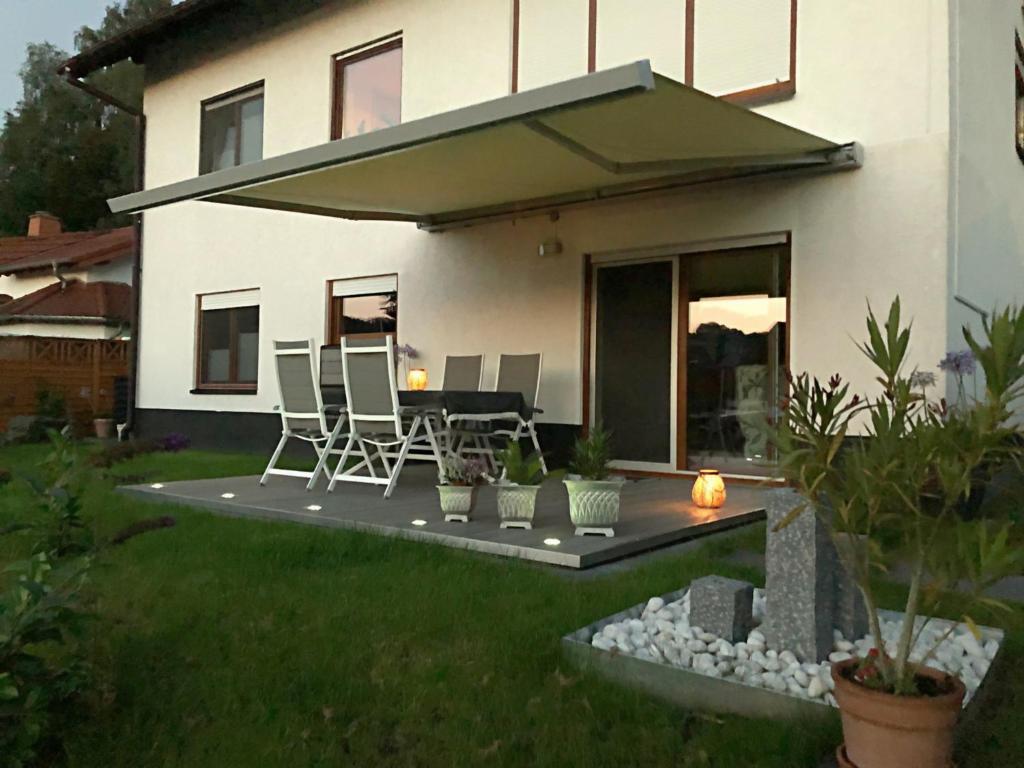 ein Haus mit einer Terrasse mit einem Tisch und Stühlen in der Unterkunft Ferienwohnung Adler in Bad Salzungen