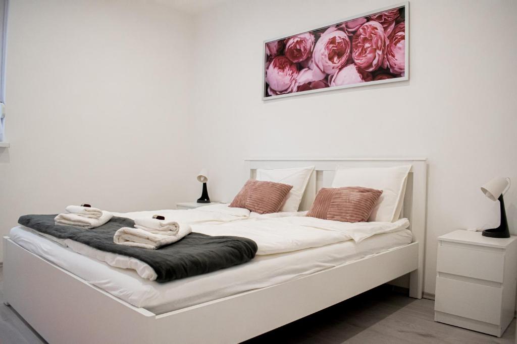 uma cama branca com toalhas num quarto em FodorMenta Residence em Eger