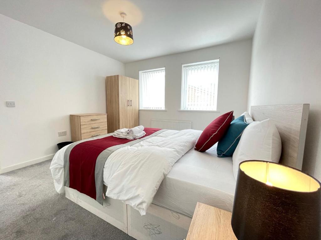 達拉謨的住宿－Moor View Professional Let，卧室配有白色大床和红色和蓝色枕头