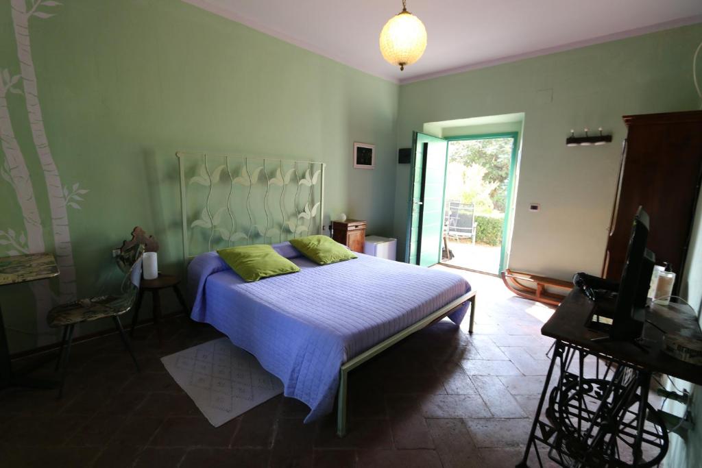 セスト・カレンデにあるB&B Coco Locoのベッドルーム1室(青いシーツと緑の枕が備わるベッド1台付)