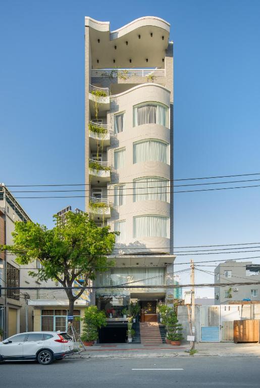 a tall building with a car parked in front of it at Thanh Lan Riverside Hotel Da Nang in Danang