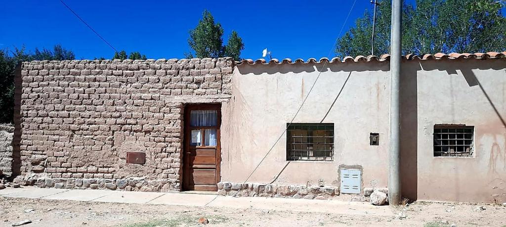 a stone building with a wooden door and windows at Hostel Casa de Familia in Humahuaca